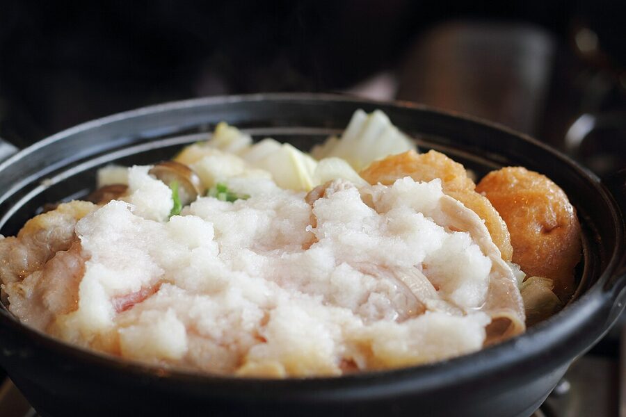 A clay pot of mizore-nabe with grated daikon snow on top, a winter Tokyo specialty paired with hot sake