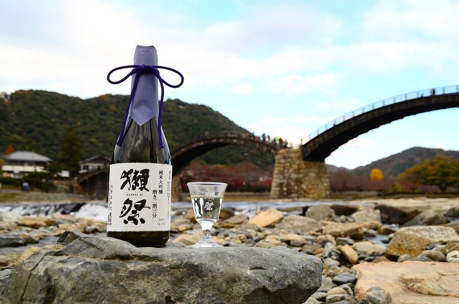 A bottle of Dassai sake displayed in front of the Kintaikyo bridge in Iwakuni