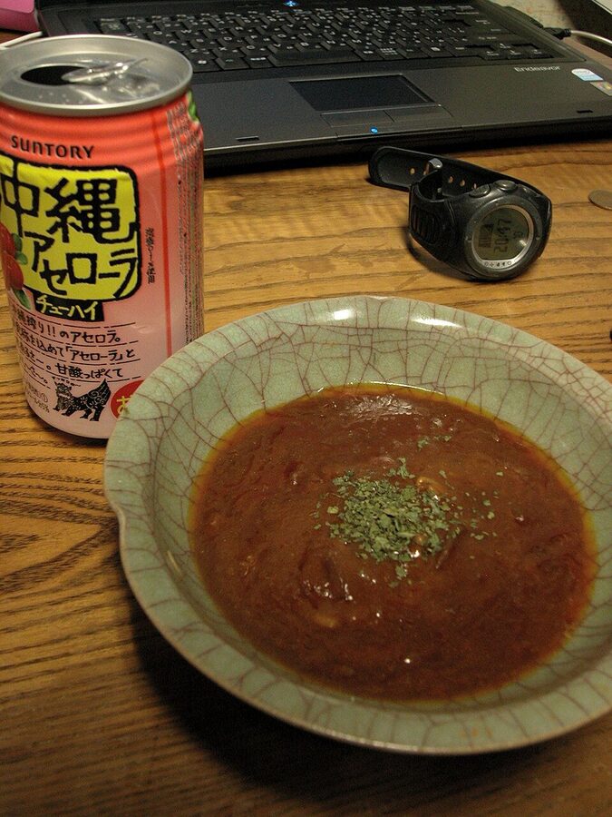 A canned chu-hi opened next to a small dish of stew on a Japanese table