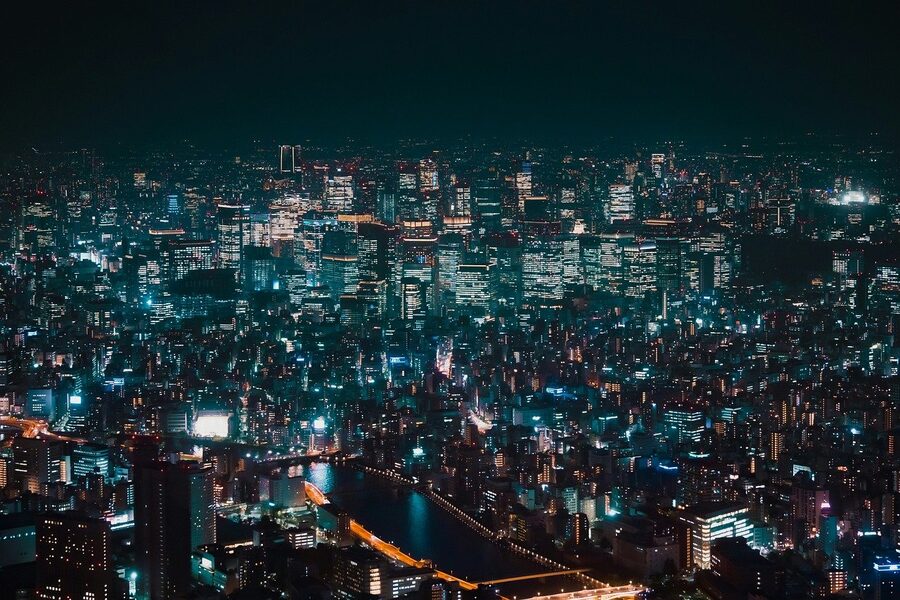 Tokyo street at night with neon signs and people walking