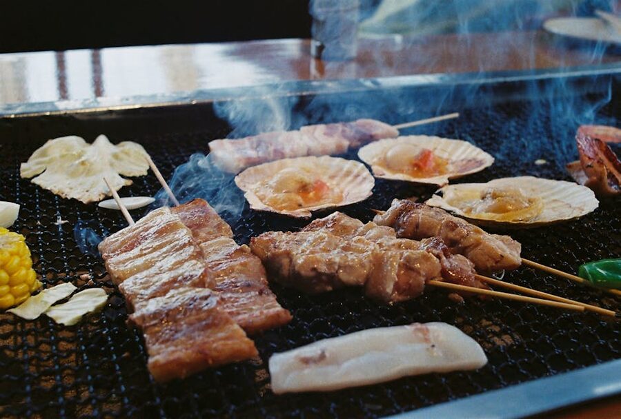 Skewers of meat sizzling over a robata charcoal grill