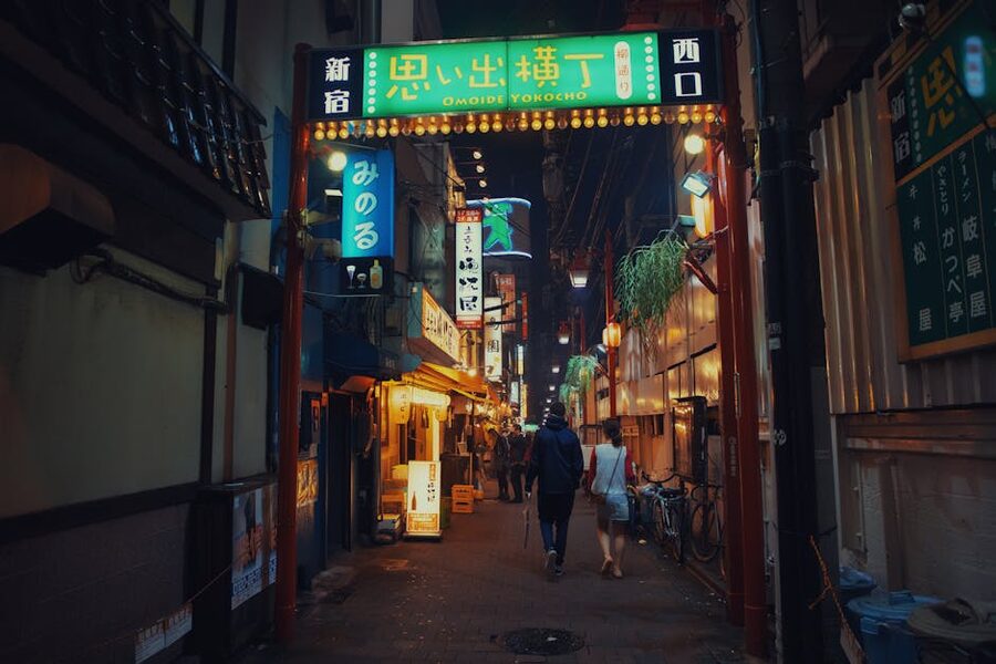 People dining and drinking at outdoor counters in Shinjuku Omoide Yokocho
