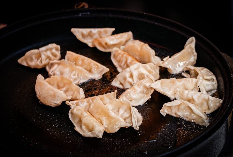 Pan-fried gyoza dumplings sizzling on a skillet