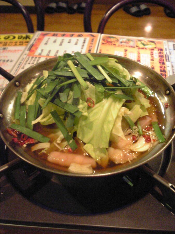 Pot of motsunabe with offal, cabbage and chives in soy broth