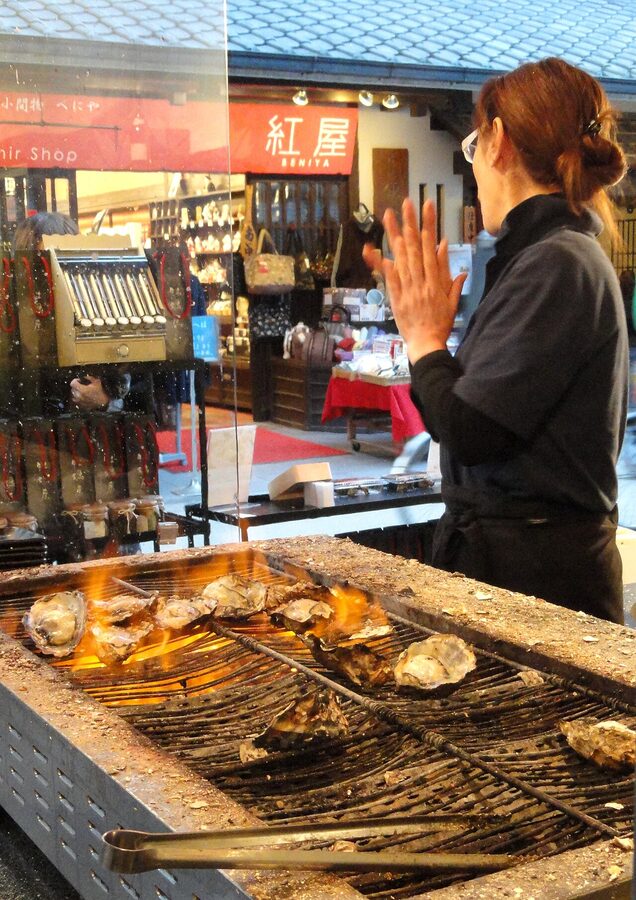 Open grilled oyster yakigaki in shell with charred edges and clear juice