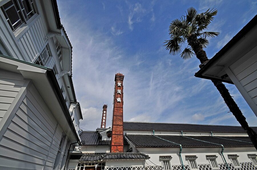 Tall red brick chimney rising above a Saijo sake brewery in Higashi-Hiroshima