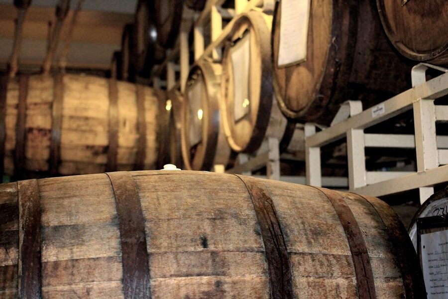 Stacked oak whisky casks in a warehouse