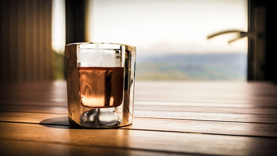 A whisky glass on a wooden bar counter