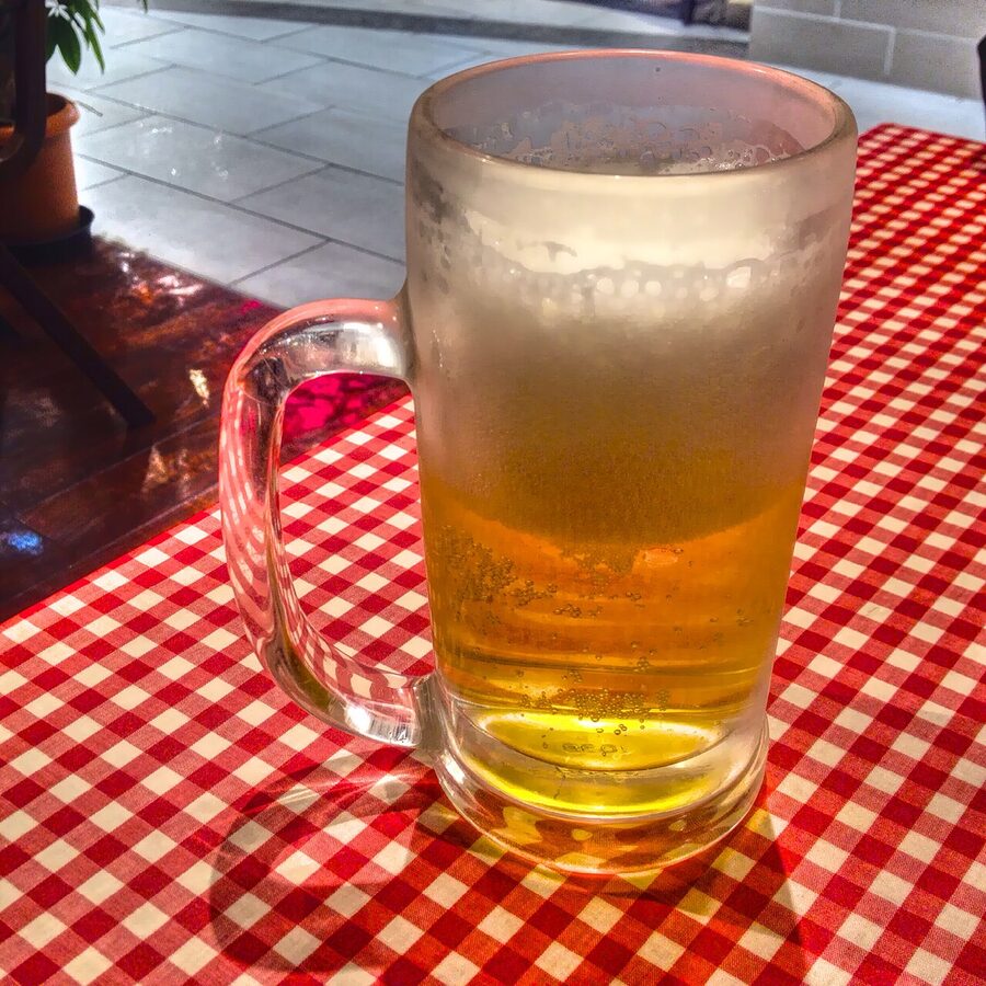 A frosty Japanese beer mug filled with golden draft beer at a Tokyo bar