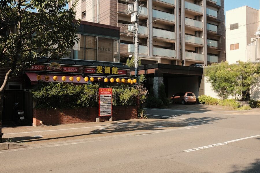 Traditional izakaya exterior at night with red lantern signage and Japanese characters above the entrance