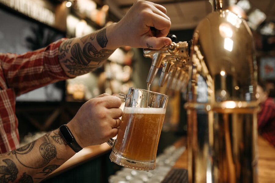 Bartender pouring craft beer into a pint glass