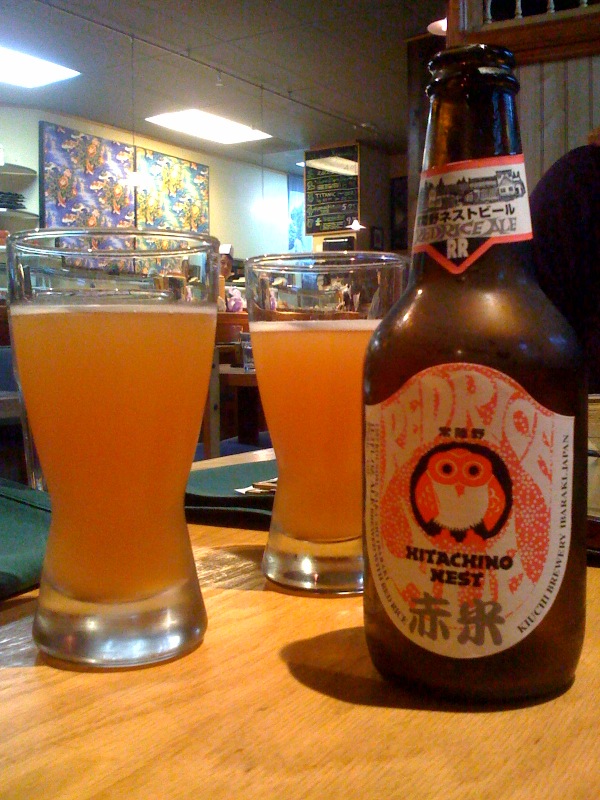 Bottle of Hitachino Red Rice Ale next to a half-poured glass