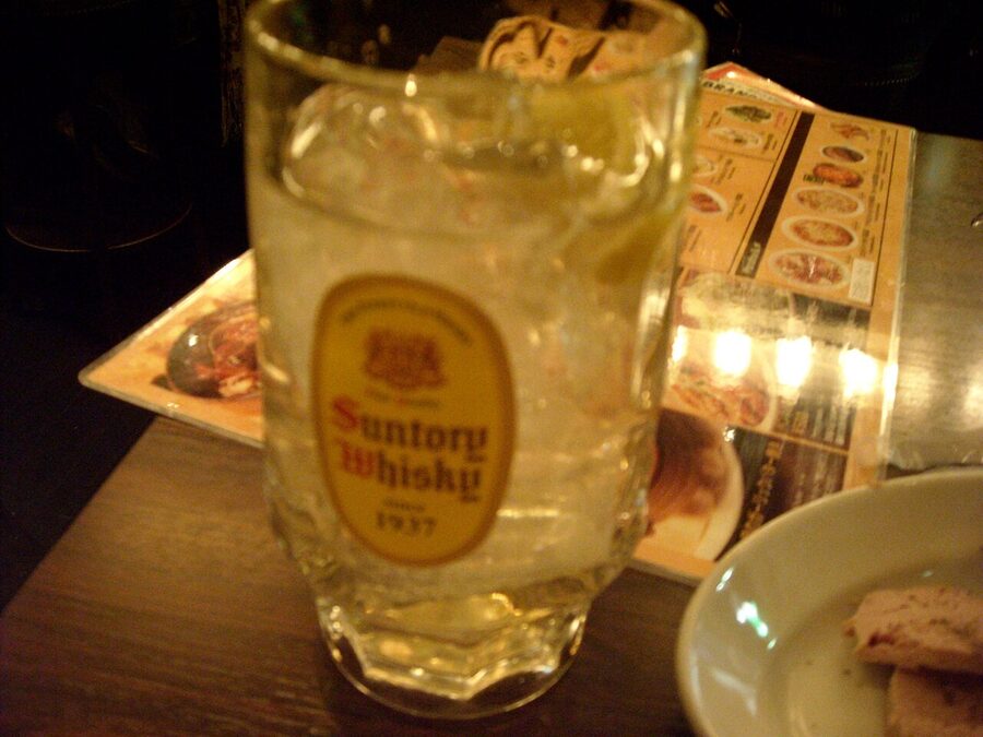 A whisky highball glass mid-pour, the moment soda meets ice