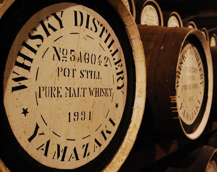 Rows of whisky barrels stacked in an aging warehouse