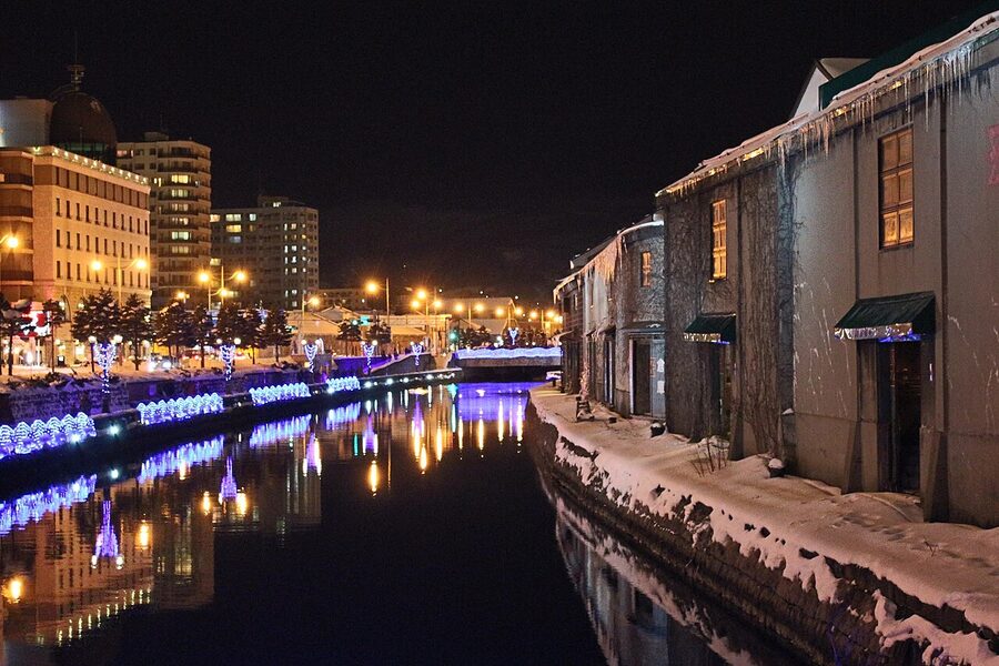 Otaru canal at night with stone warehouses and water reflections
