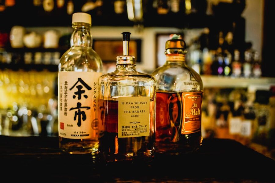 Selection of Japanese whisky bottles on a backlit Tokyo bar shelf