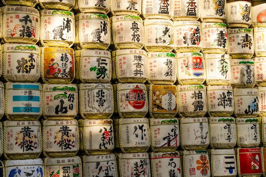 Stacked sake barrels at Meiji Shrine in Tokyo with calligraphy on the labels