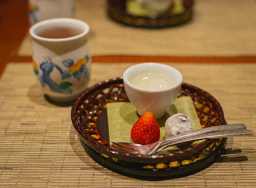 Sake being poured into a small ochoko cup at a brewery tasting