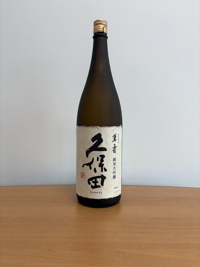 A bottle of Kubota Junmai Daiginjo with a black label and gold accents