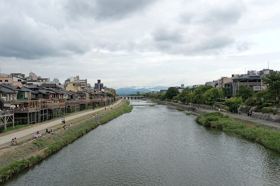 Kamogawa river flowing through Kyoto with cityscape and mountains