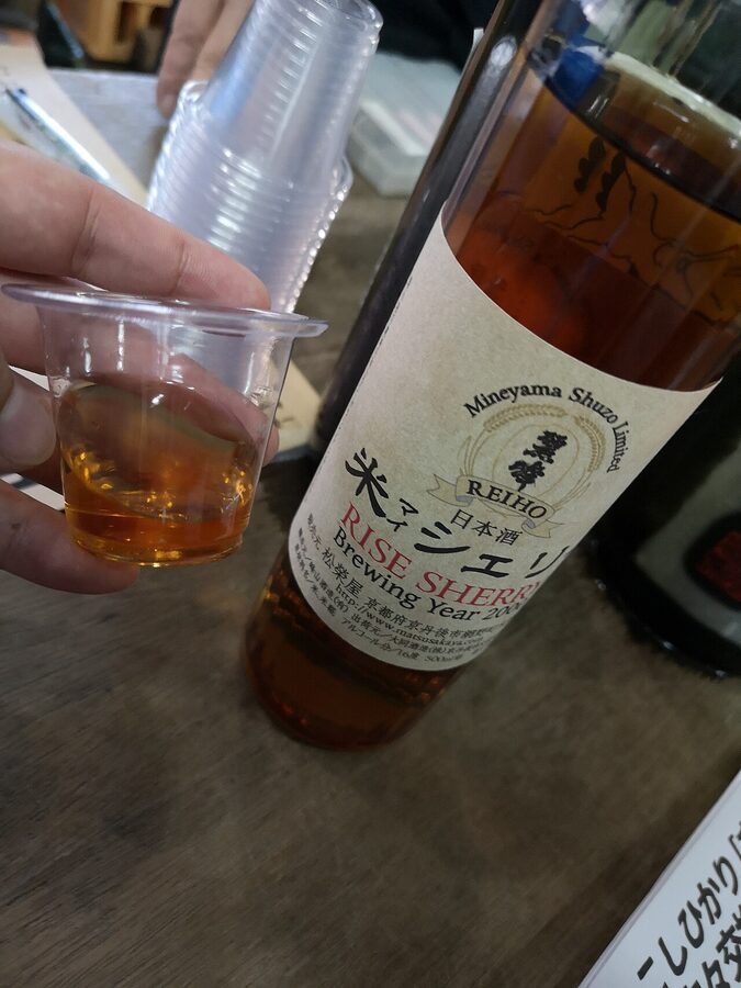 A bottle of Mineyama Brewery koshu aged sake with amber liquid visible