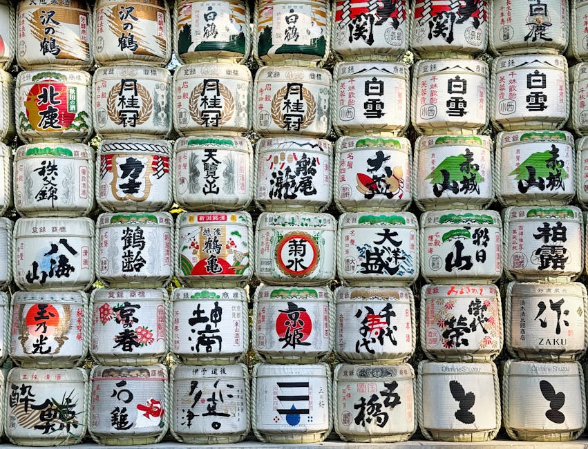 Stack of traditional Japanese sake barrels with kanji labels