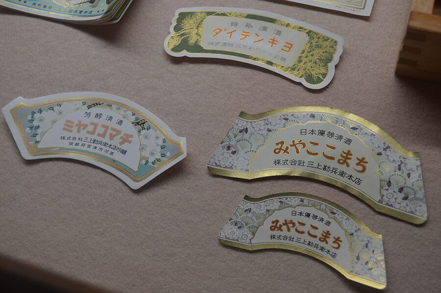 Detail of an old Mikami House sake label with vertical kanji and printed seals