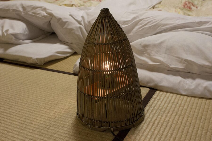 Japanese-style room with futon and tatami illuminated by warm light