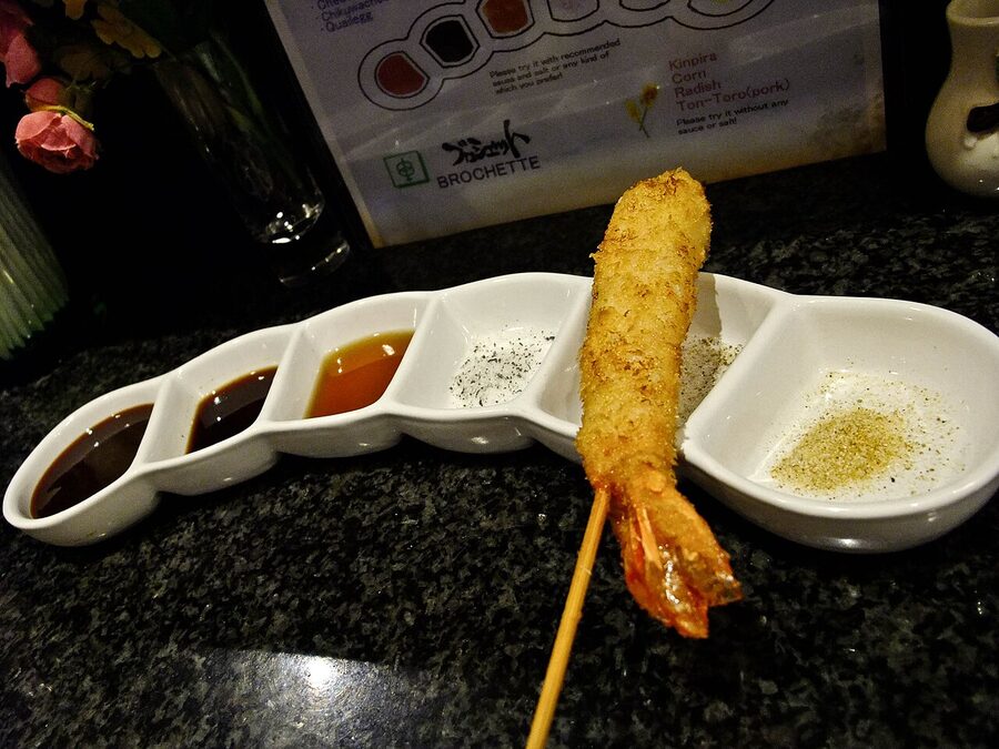 Kushikatsu fried skewers stacked on a plate, golden brown breaded coating