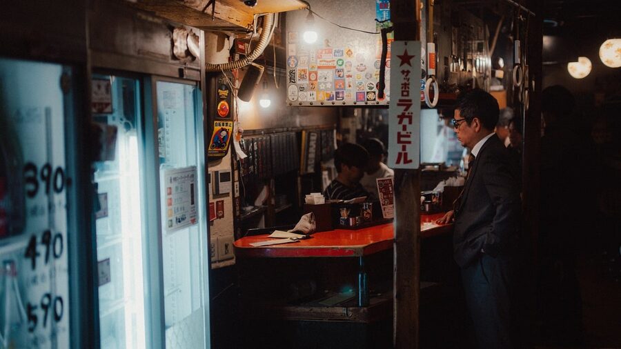 Neon-lit bar exteriors in Osaka at night with signs and a moody street feel