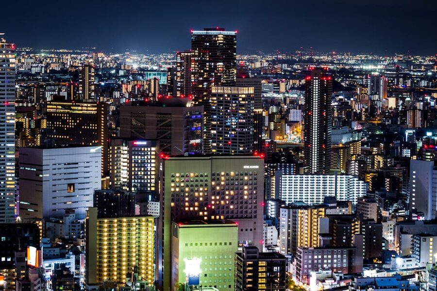 Osaka skyline at night with skyscrapers lit up and reflections on water