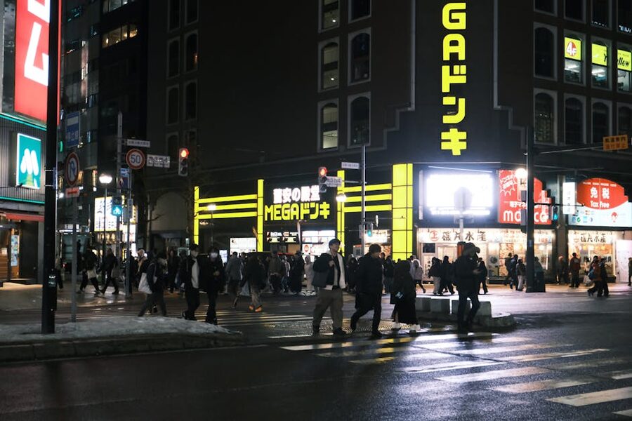 A pedestrian street at night with neon signage and crowds