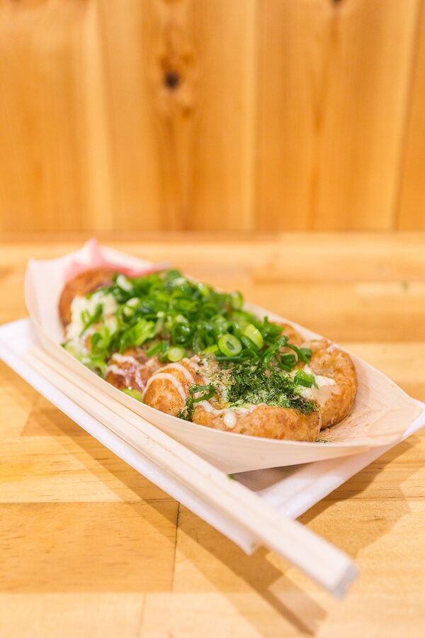 Honke Otako takoyaki in Osaka, fresh batch on tray with sauces and bonito flakes