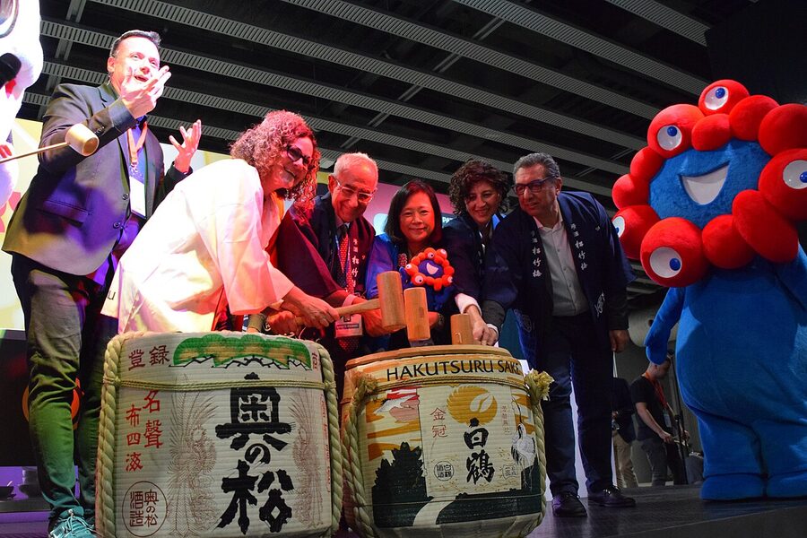 Wooden mallets raised to strike open a sake cask at a kagami biraki ceremony