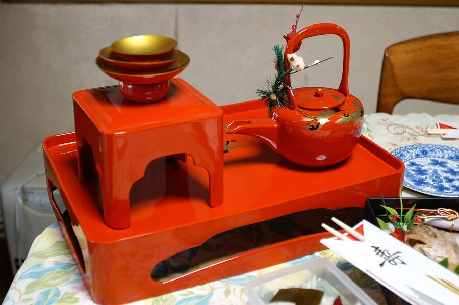 A complete otoso tosoki set with three stacked lacquer cups, the choshi pourer, and the stand