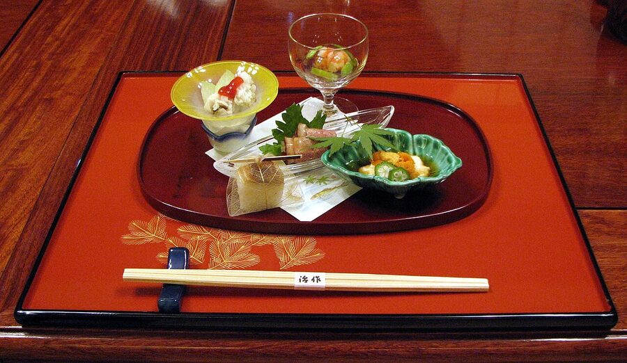 A multi-course kaiseki meal arrayed in lacquer bowls, the kind of meal where kuchitorizake plays a structural role