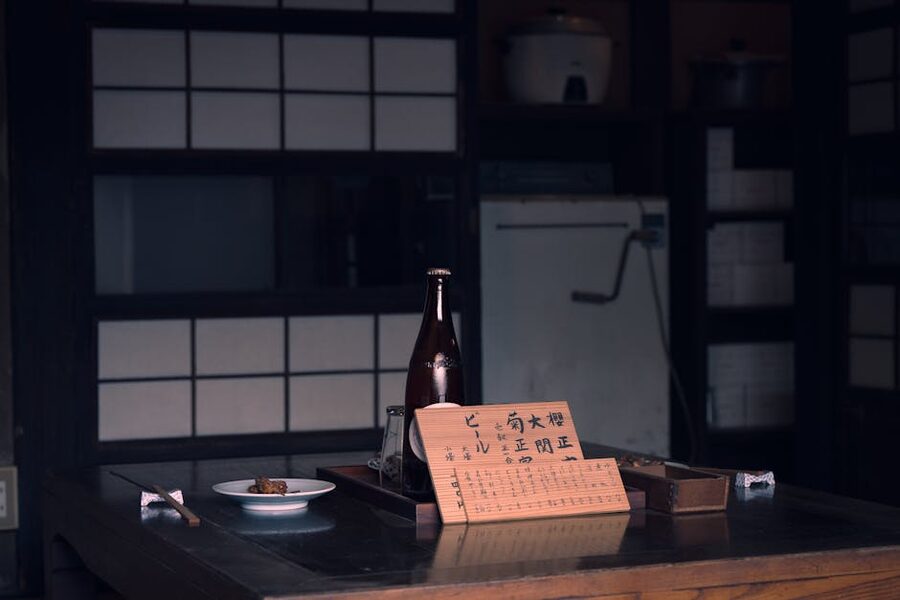 A traditional Japanese table set with a sake bottle and a hand-written menu card, the standard ryokan dinner setup