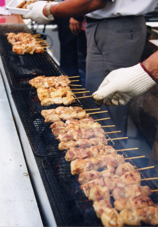 Yakitori being grilled over hot coals, the everyday Japanese drink-and-snack pairing
