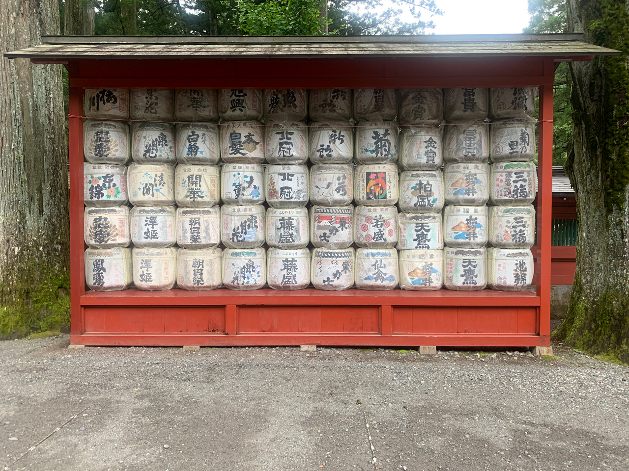 Decorated sake barrels stacked in front of a shrine in Nikko