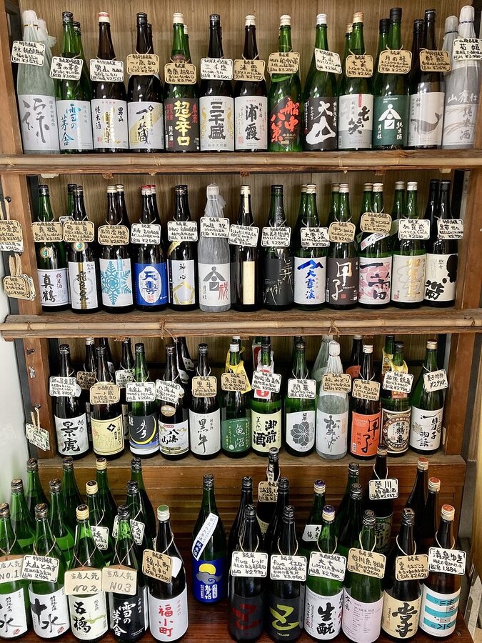 Sake bottles in glass cases at a Japanese liquor shop
