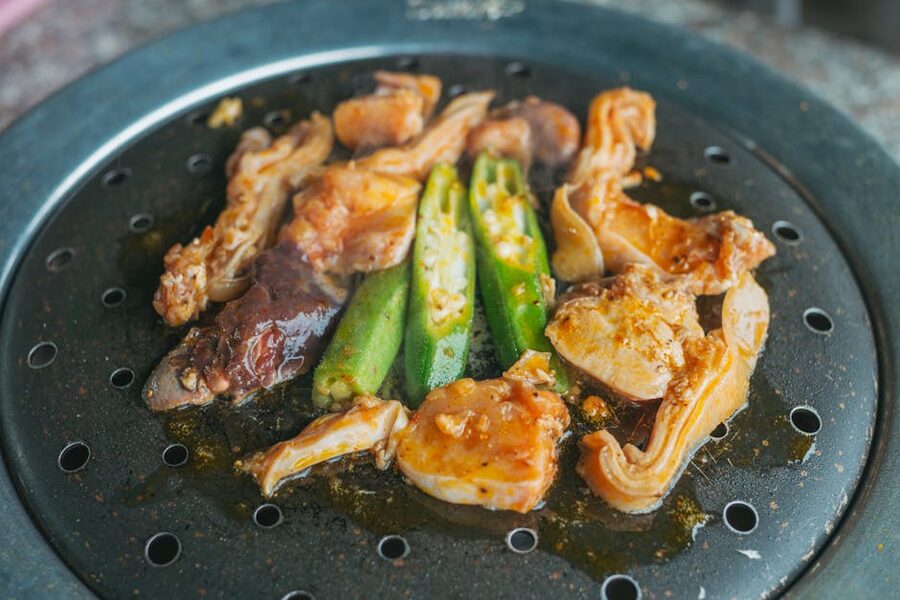 Cooked food on a round iron Genghis Khan grill