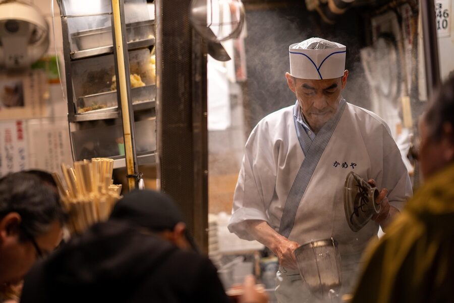 Yakitori cook plating skewers in an izakaya