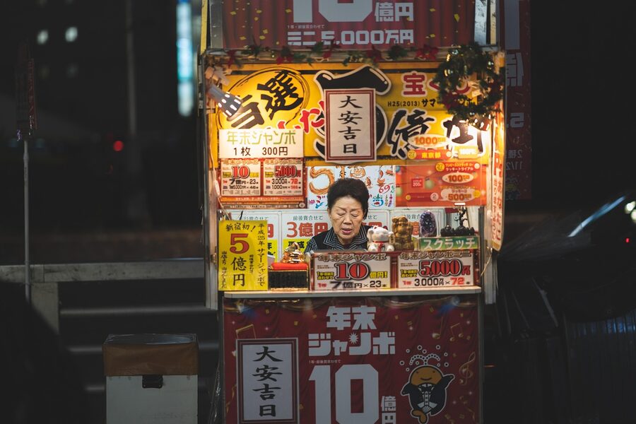 Shinjuku night street with a small kiosk and signage