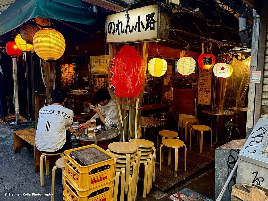 Bar patrons standing at a Harmonica Yokocho counter in Kichijoji