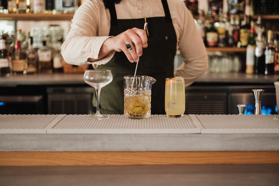 Bartender crafting cocktails at a well-stocked Tokyo bar