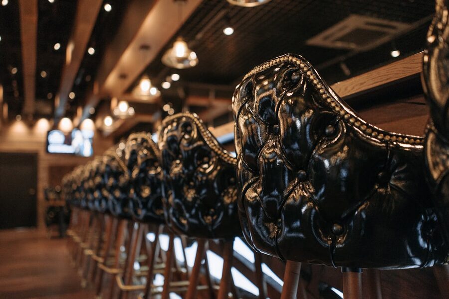 Leather bar stools at a softly lit cocktail counter