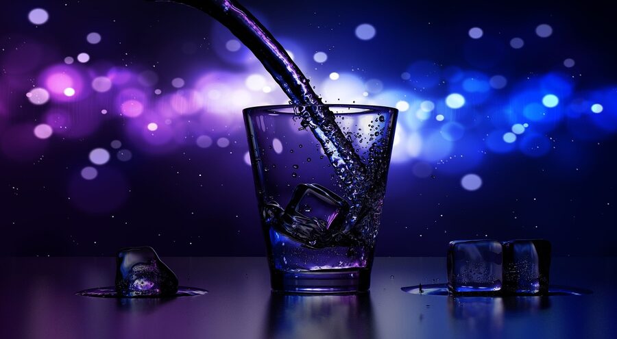 Pouring spirit over ice in a tumbler