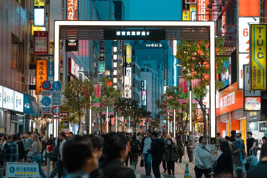 Shinjuku at night with neon signs and salaryman crowds