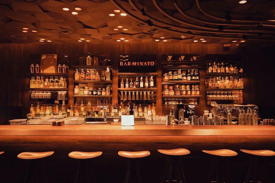 Warm wooden whisky bar interior with extensive backbar bottle display