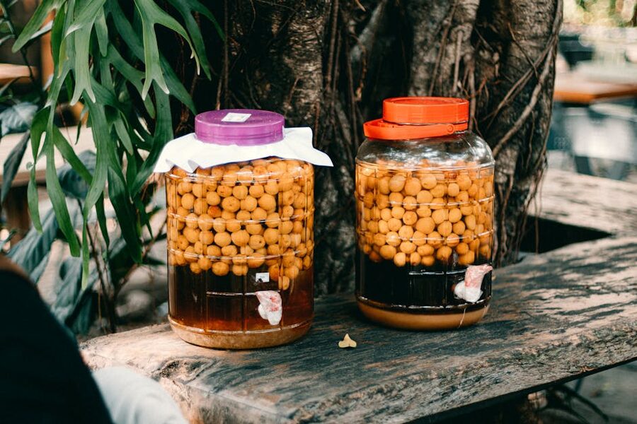 Homemade fruit jars on a wooden table, the format every Japanese household uses for umeshu